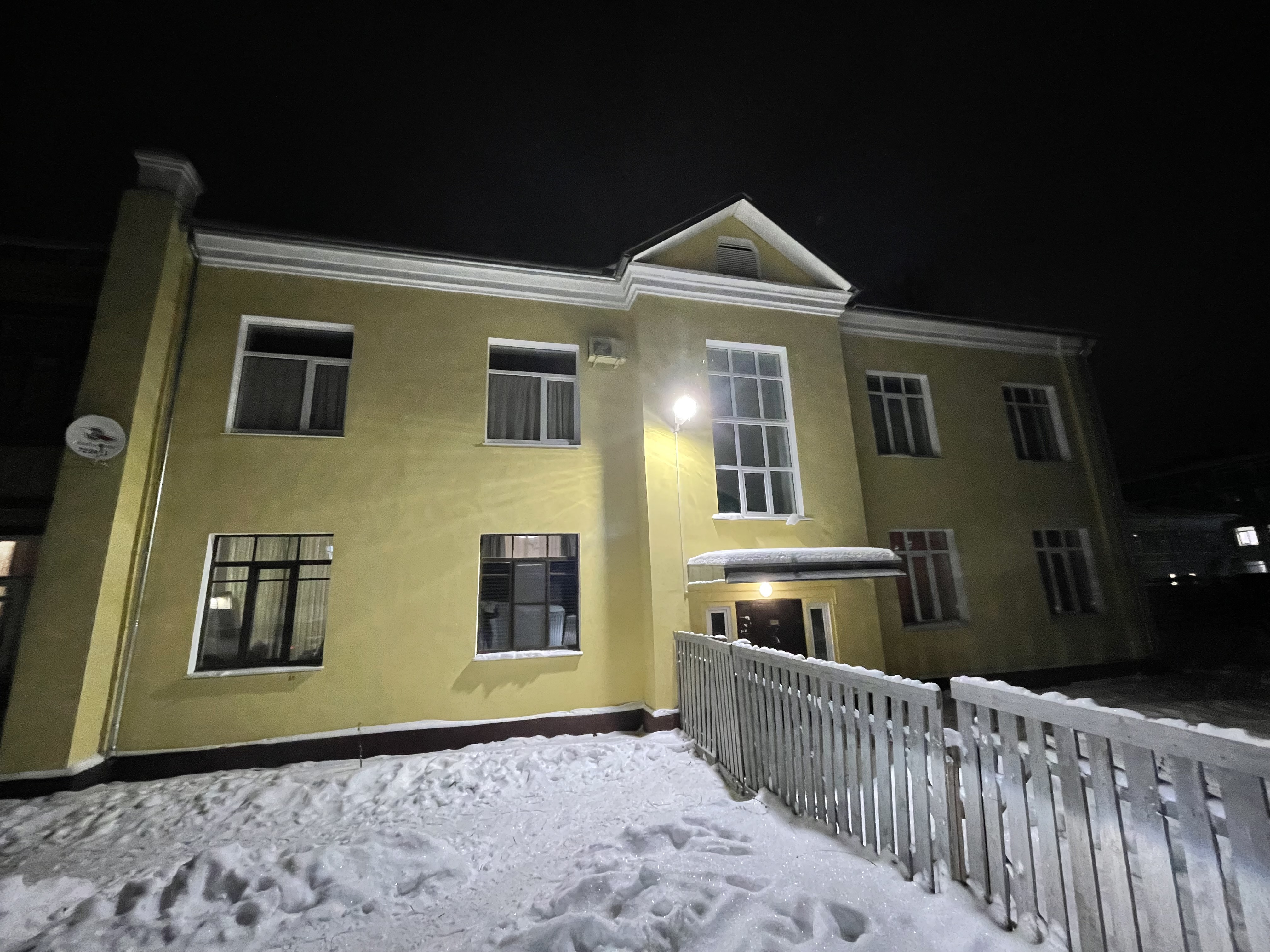 Каменный дом с апартаментами VologDom зимним вечером